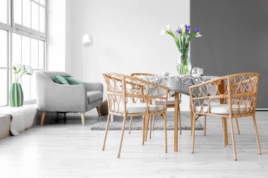 Odadaki yemek masasında güzel süsen çiçekleri olan vazo.