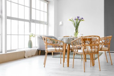 Odadaki yemek masasında güzel süsen çiçekleri olan vazo.