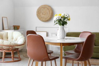 Odadaki yemek masasında güzel kasımpatı çiçekleri olan vazo.