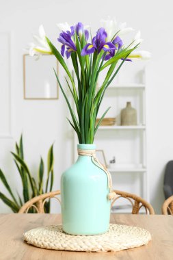 Odadaki yemek masasında güzel süsen çiçekleri olan vazo.