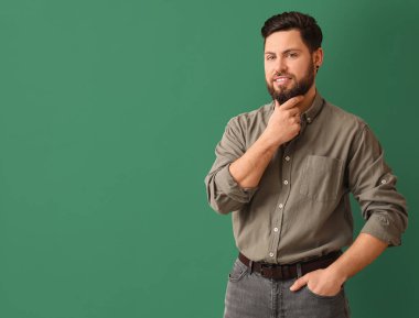 Yeşil arka planda şık sakallı adam.