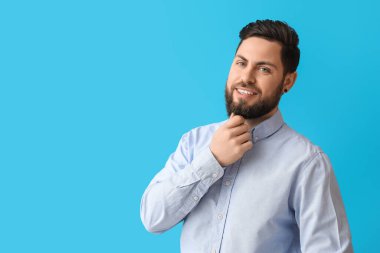 Mavi arka planda şık sakallı adam