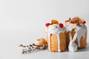 Delicious Easter cakes, pussy willow branches and egg on light background