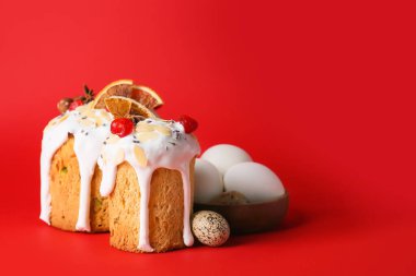 Lezzetli paskalya pastaları ve kırmızı arka planda yumurtalar.