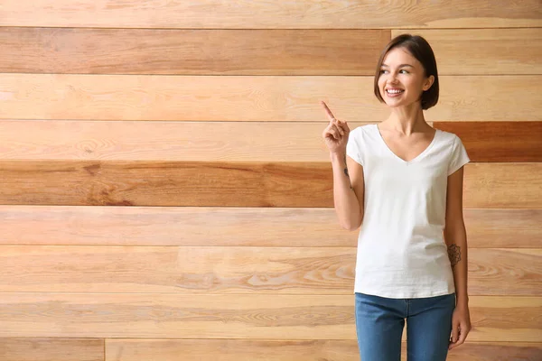 Beautiful Young Woman Stylish Shirt Pointing Something Wooden Background — Stock Photo, Image