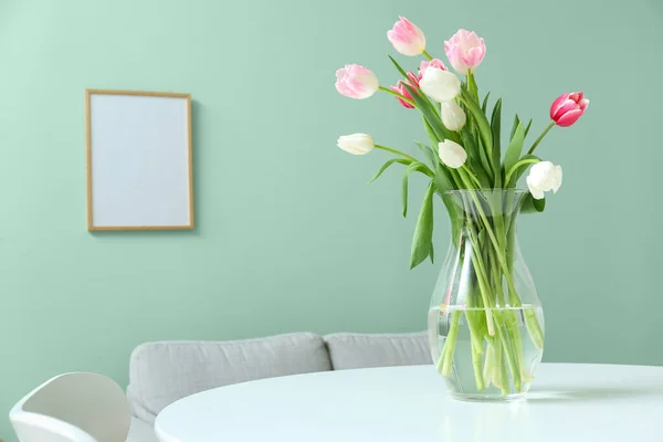 部屋のダイニングテーブルの上に美しいチューリップの花と花瓶 — ストック写真