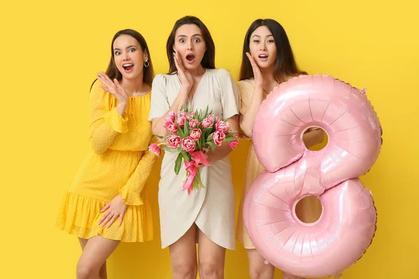 Sarı Arka Planda Bir Buket Çiçekli Balonlu Güzel Sürpriz Kadınlar — Stok fotoğraf
