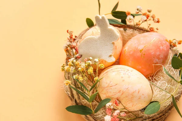 Renkli Arka Planda Boyanmış Paskalya Yumurtaları Tavşan Çiçeklerle Dolu Yuva — Stok fotoğraf