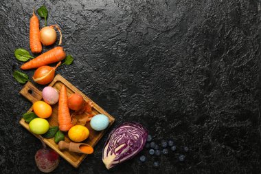 Paskalya yumurtalı ahşap tahta ve arka planda doğal boyalar.