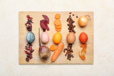 Güzel Paskalya yumurtaları ve açık arkaplanda doğal boyalar olan ahşap tahta tahta.