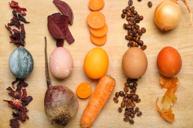 Güzel Paskalya yumurtaları ve ahşap arka planda doğal boyalar.