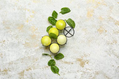 Paskalya yumurtaları ve arka planda ıspanak yaprakları olan tutucu.