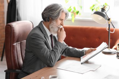 Ofiste çalışan olgun sakallı bir iş adamı.