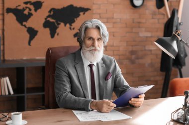 Ofiste çalışan olgun sakallı bir iş adamı.