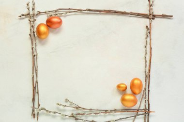 Frame made of Easter eggs and pussy willow branches on light background