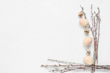 Composition with Easter eggs and pussy willow branches on light background