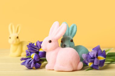 Sarı arka planda güzel Paskalya tavşanları ve çiçekler