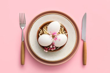 Paskalya kutlaması için güzel bir masa ve pembe arka planda çiçekler.