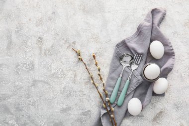 Beautiful table setting for Easter celebration and pussy willow branches on grey background