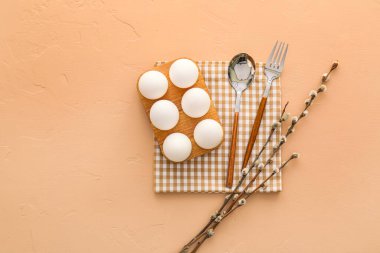 Beautiful table setting for Easter celebration and pussy willow branches on beige background