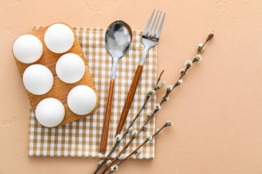 Beautiful table setting for Easter celebration and pussy willow branches on beige background