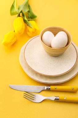 Paskalya kutlaması için güzel bir masa ve arka planda çiçekler, yakın plan.