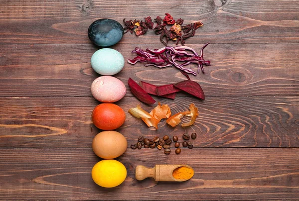 Beautiful Easter eggs and natural dyes on wooden background