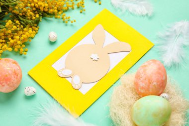 Güzel Paskalya kompozisyonu tebrik kartı, renkli arka planda boyanmış yumurta ve çiçekler, yakın plan