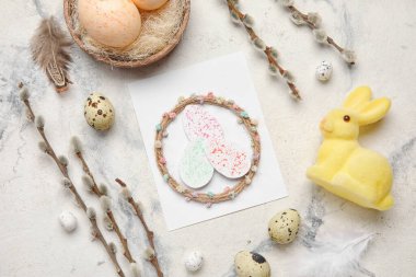 Beautiful Easter composition with greeting card, eggs, bunny and pussy willow branches on light background