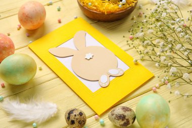 Güzel Paskalya kompozisyonu, tebrik kartı, renkli yumurta ve çiçekler ahşap arka plan, yakın plan.