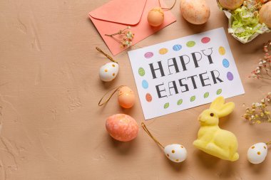 Güzel Paskalya kompozisyonu tebrik kartı, boyalı yumurta, tavşan ve çiçeklerle renklendirilmiş.