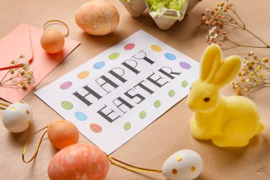 Güzel Paskalya kompozisyonu tebrik kartı, renkli yumurta, tavşan ve çiçeklerle yakın plan,