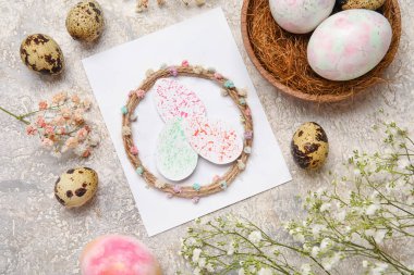 Tebrik kartı, paskalya yumurtası ve gri arka planda çiçekli güzel kompozisyon