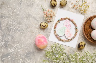 Tebrik kartı, paskalya yumurtası ve gri arka planda çiçekli güzel kompozisyon