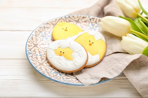 Tallrik Med Välsmakande Påsk Cookies Och Blommor Ljus Trä Bakgrund — Stockfoto