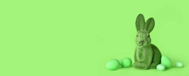 Yeşil zemin üzerinde Paskalya tavşanı ve yumurtalar.