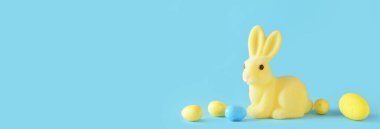 Mavi arkaplanda paskalya tavşanı ve yumurtaları metin için yer var