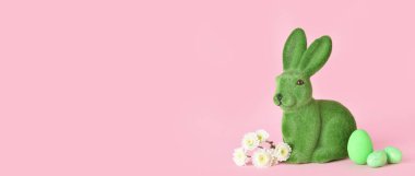 Paskalya tavşanı, pembe arka planda yumurtalar ve çiçekler metin için yer var.