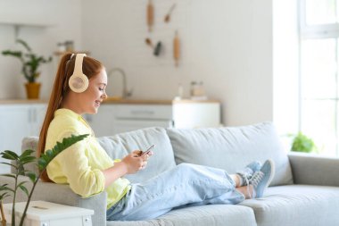 Evde müzik dinleyen havalı genç bir kadın.