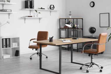 Masa, sandalye ve lambalı modern ofis.