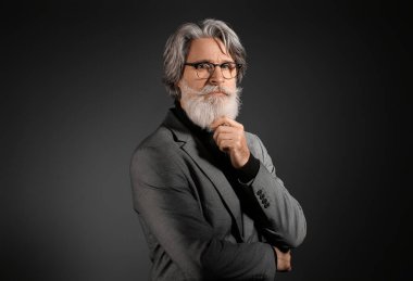 Esmer arka planda yakışıklı, olgun sakallı iş adamı portresi.