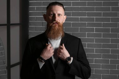 Karanlık odadaki yakışıklı sakallı adamın portresi.