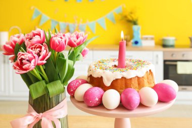 Paskalya yumurtaları, pasta ve güzel lalelerin yanında dur.