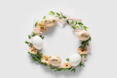 Paskalya yumurtaları ve çiçekli güzel bir çelenk.