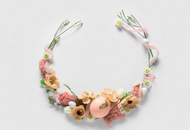 Paskalya yumurtaları ve çiçekli güzel bir çelenk.