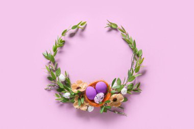 Paskalya yumurtalı güzel bir çelenk ve mor arka planda çiçekler.