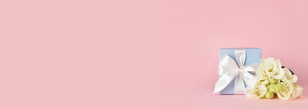Подарки и красивые цветы на розовом фоне с пространством для текста