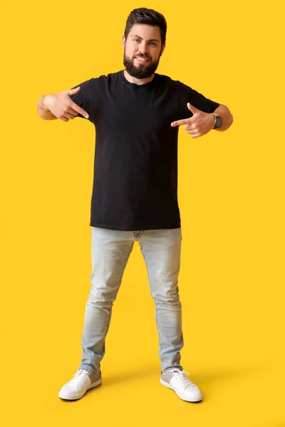 Bonito Homem Apontando Para Camiseta Preta Fundo Amarelo — Fotografia de Stock