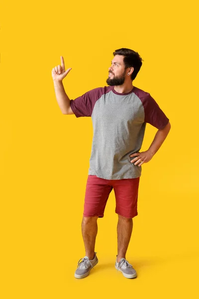 Bel Homme Shirt Pointant Quelque Chose Sur Fond Jaune — Photo