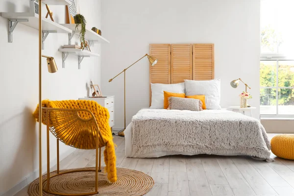 アームチェアと黄金のランプ付きの光の寝室のインテリア — ストック写真